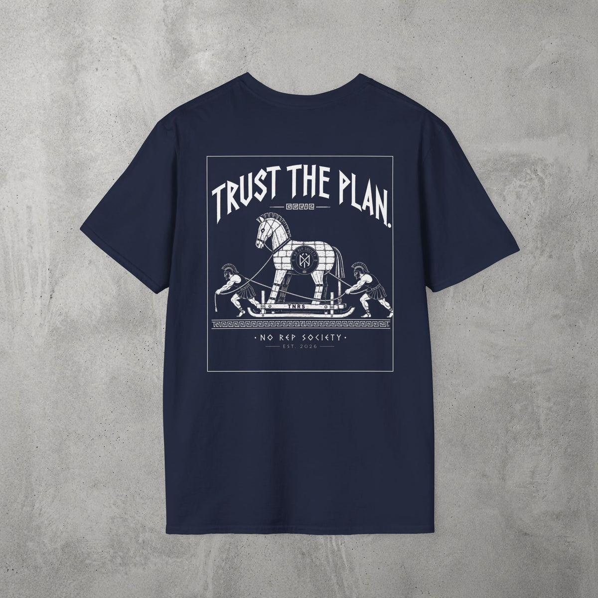 Navy Trust The Plan Tee by The No Rep Society, flat lay on grey concrete, back print of the Trojan Horse with figures around it under TRUST THE PLAN lettering.