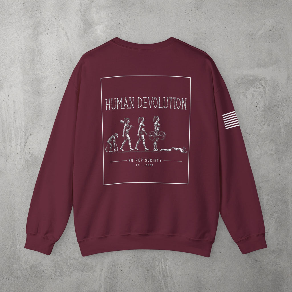 Maroon Human Devolution (WOMEN) Crewneck by The No Rep Society, flat lay on grey concrete, back print of evolution silhouettes ending face-down on the floor under HUMAN DEVOLUTION lettering.