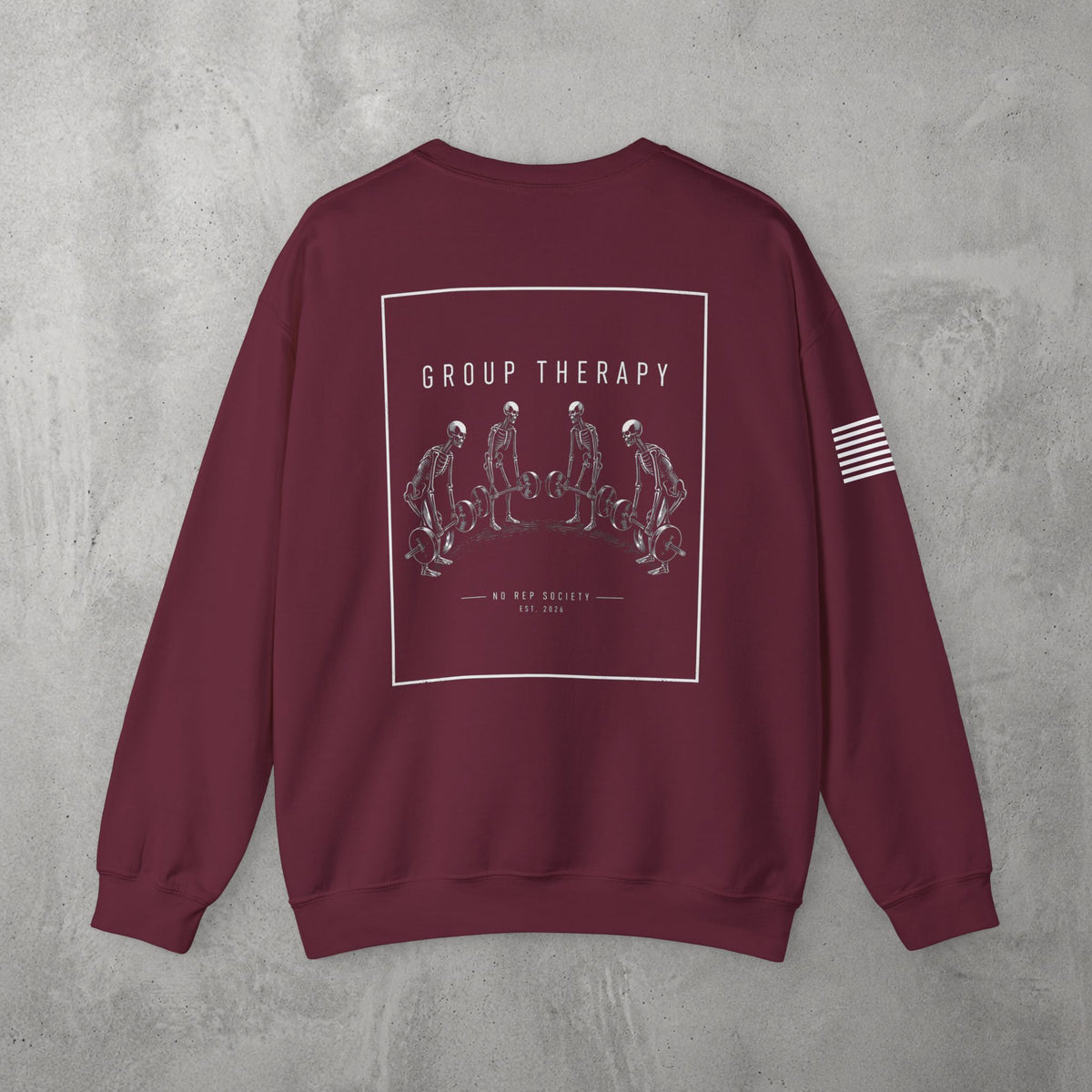 Maroon Group Therapy Crewneck by The No Rep Society, flat lay on grey concrete, back print of a circle of exhausted figures collapsed on the floor under GROUP THERAPY lettering.