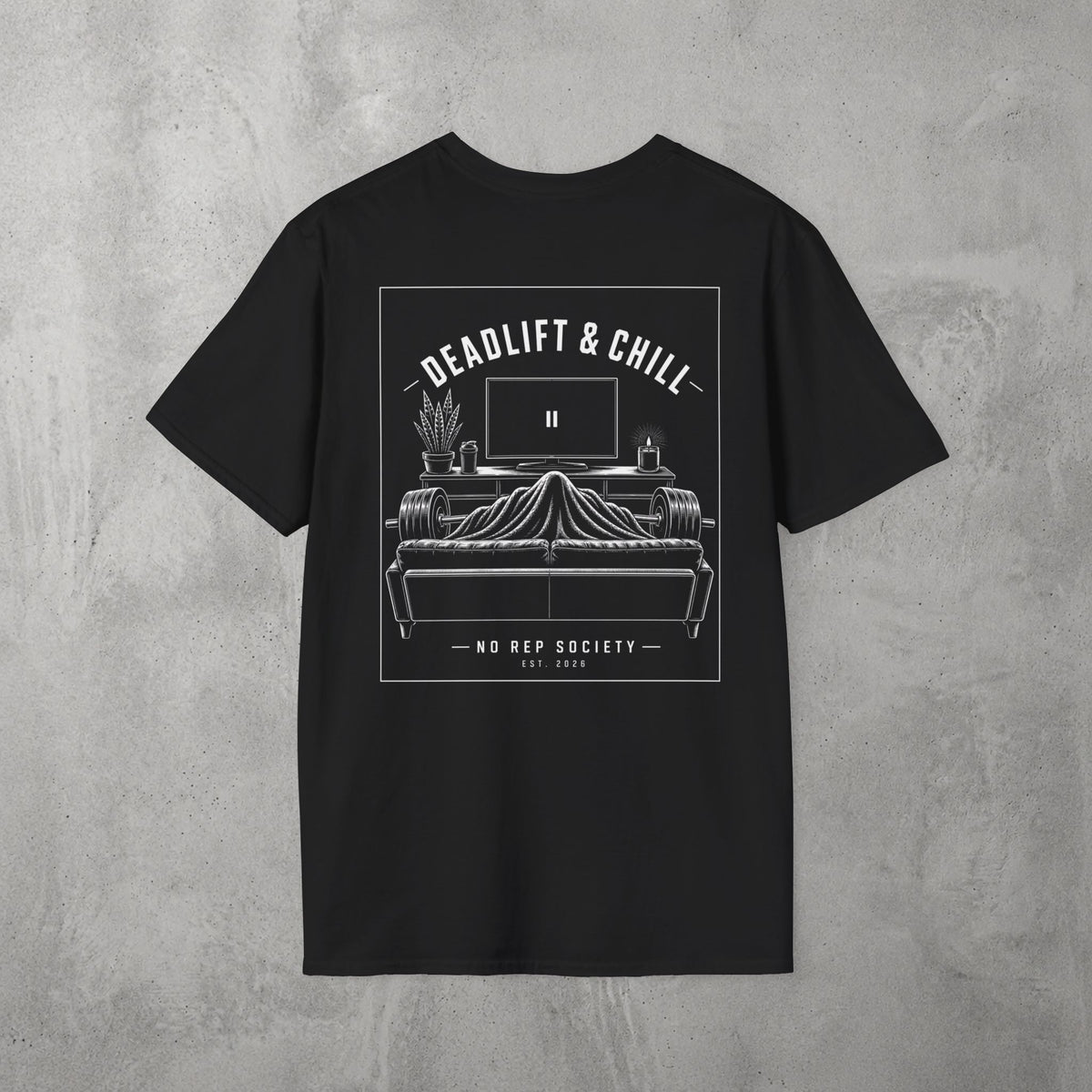 Black Deadlift & Chill Tee by The No Rep Society, flat lay on grey concrete, back print of a bed and television drawn in fine line art under DEADLIFT & CHILL lettering.