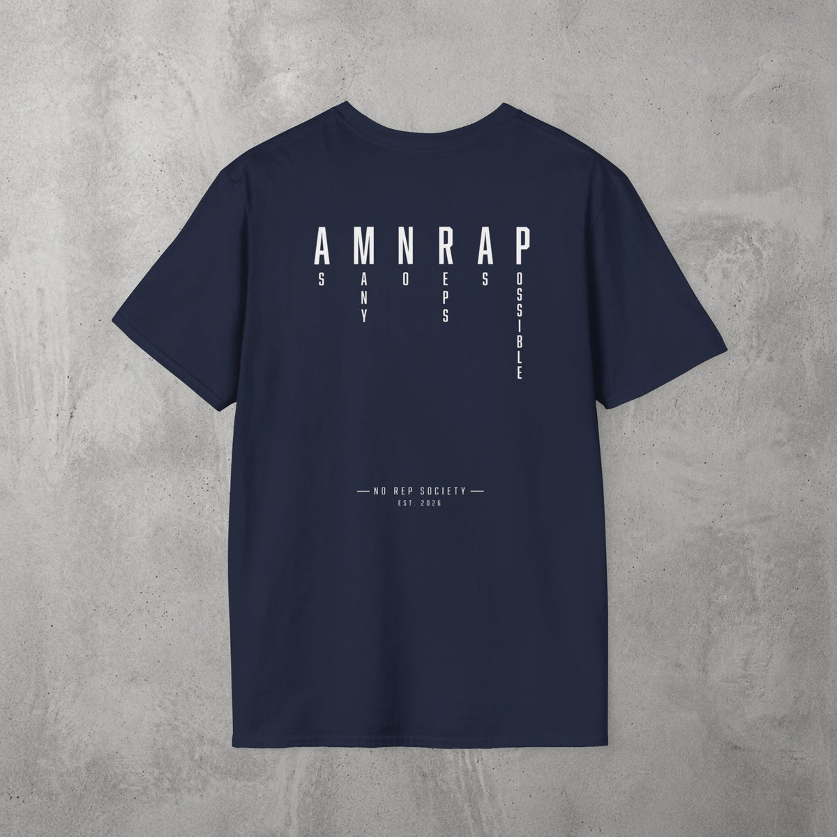 Navy AMNRAP Tee by The No Rep Society, flat lay on grey concrete, back print of AMNRAP in wide spaced capitals with AS MANY NO-REPS AS POSSIBLE set vertically between the letters.