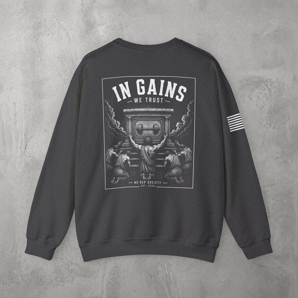 Dark Heather In Gains We Trust Crewneck by The No Rep Society, flat lay on grey concrete, back print of an ornate temple facade with two kneeling figures and laurel branches under IN GAINS WE TRUST lettering.