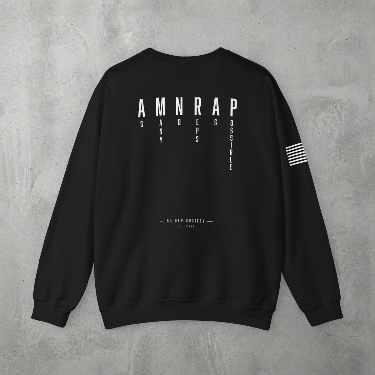 Black AMNRAP Crewneck by The No Rep Society, flat lay on grey concrete, back print of AMNRAP in wide spaced capitals with AS MANY NO-REPS AS POSSIBLE set vertically between the letters.