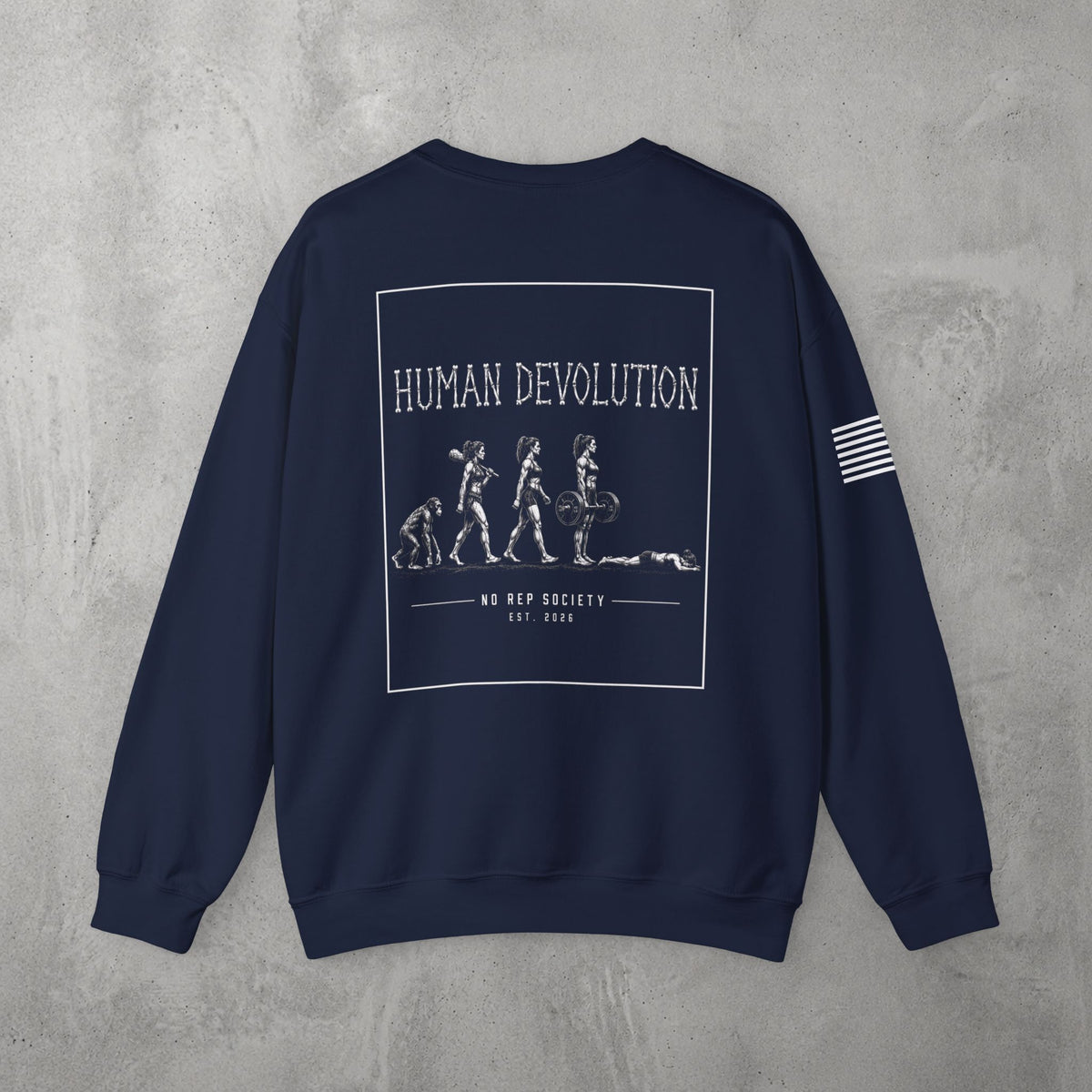 Navy Human Devolution (WOMEN) Crewneck by The No Rep Society, flat lay on grey concrete, back print of evolution silhouettes ending face-down on the floor under HUMAN DEVOLUTION lettering.