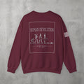 Maroon Human Devolution (MEN) Crewneck by The No Rep Society, flat lay on grey concrete, back print of evolution-of-man silhouettes ending face-down on the floor under HUMAN DEVOLUTION lettering.