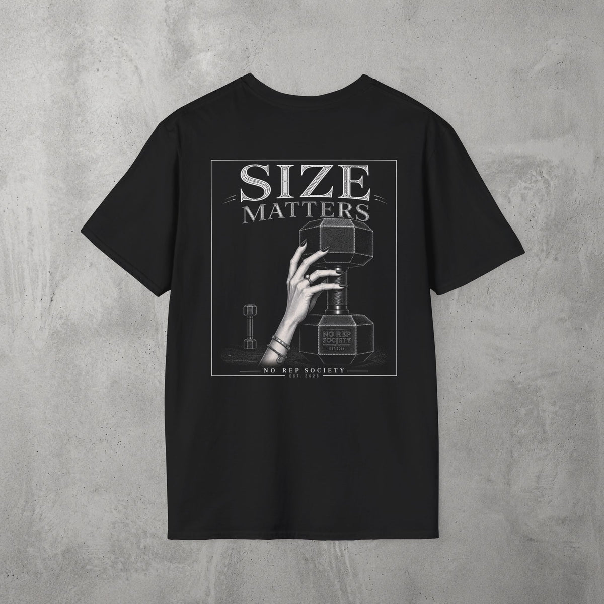Black Size Matters Tee by The No Rep Society, flat lay on grey concrete, back print of a hand gripping a large weight plate under SIZE MATTERS lettering.