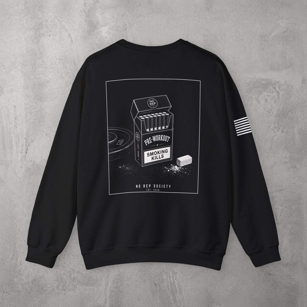 Black Pre-Workout Crewneck by The No Rep Society, flat lay on grey concrete, back print of an open cigarette pack labelled PRE-WORKOUT with a SMOKING KILLS warning and a scoop spilling powder.