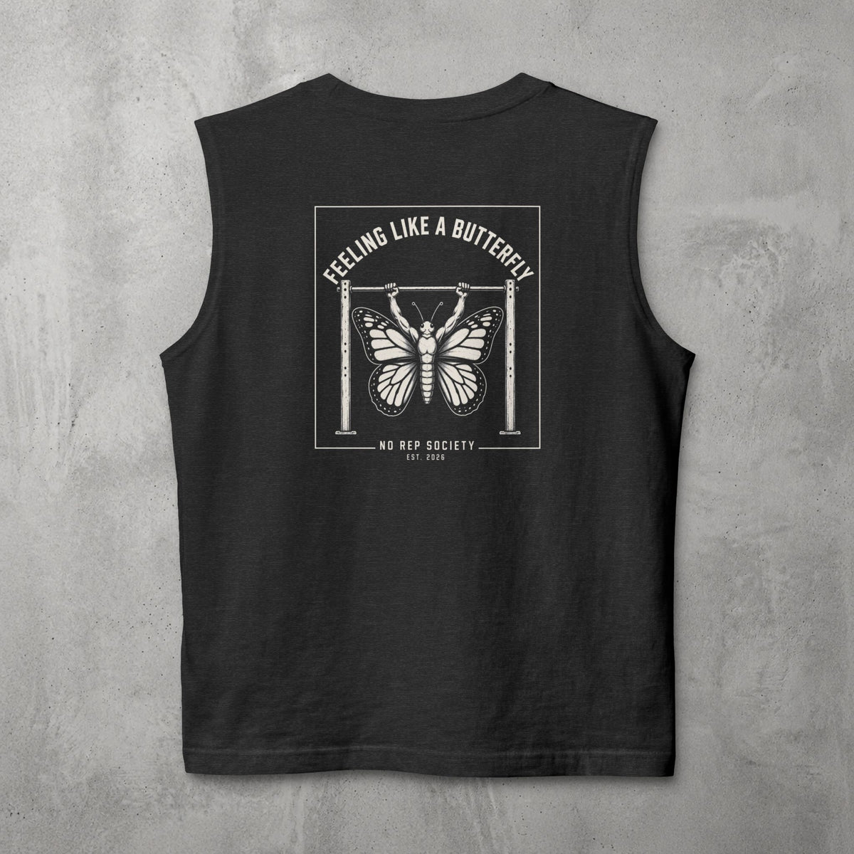 Dark Grey Heather Feeling Like A Butterfly Muscle Tank by The No Rep Society, flat lay on grey concrete, back print of a moth with spread wings hanging between two rig uprights under FEELING LIKE A BUTTERFLY lettering.