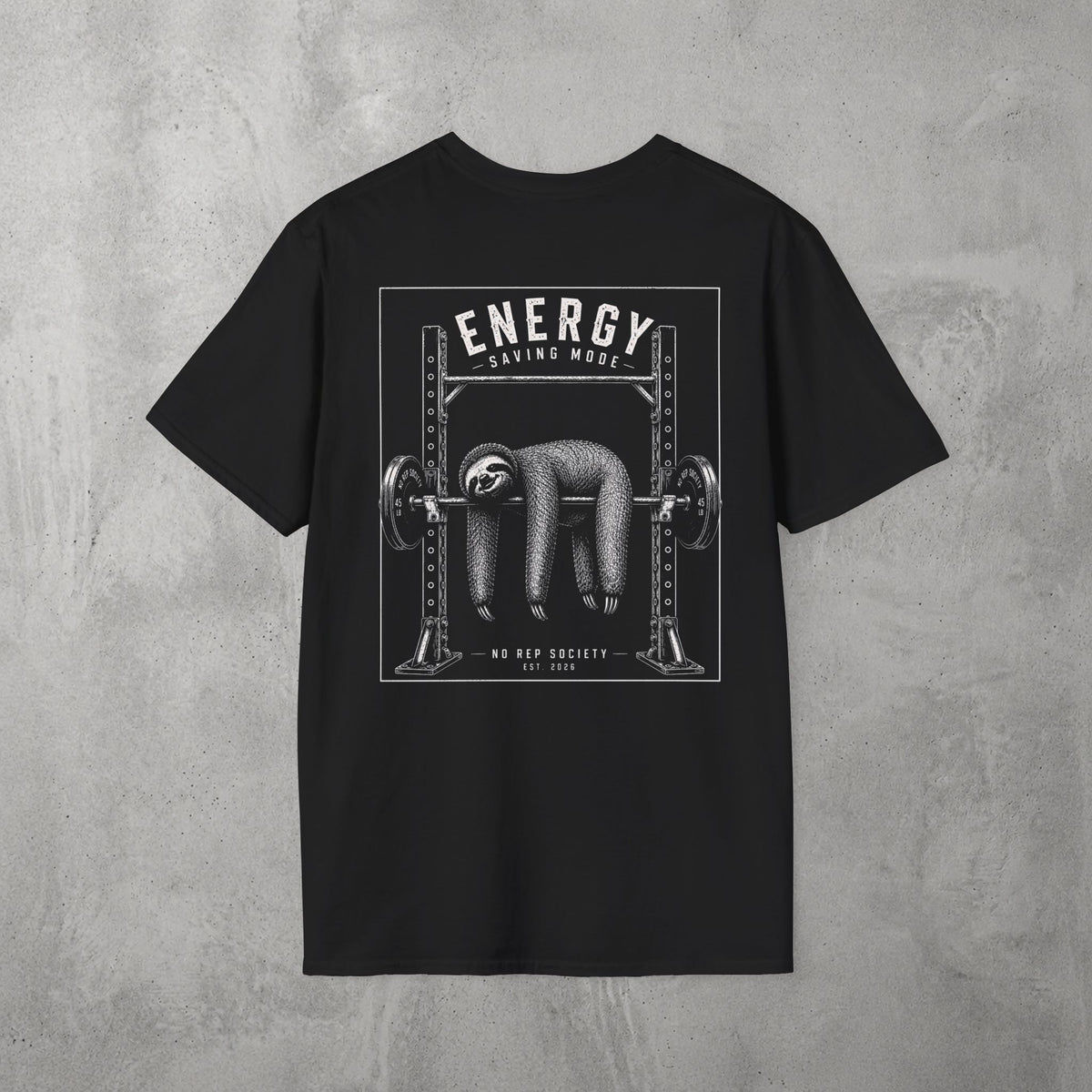 Black Energy Saving Mode Tee by The No Rep Society, flat lay on grey concrete, back print of a sloth hanging from a loaded barbell in a squat rack under ENERGY SAVING MODE lettering.