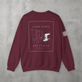 Maroon Good Times, Bad Places Crewneck by The No Rep Society, flat lay on grey concrete, back print of a rowing machine in fine line art between GOOD TIMES and BAD PLACES lettering.