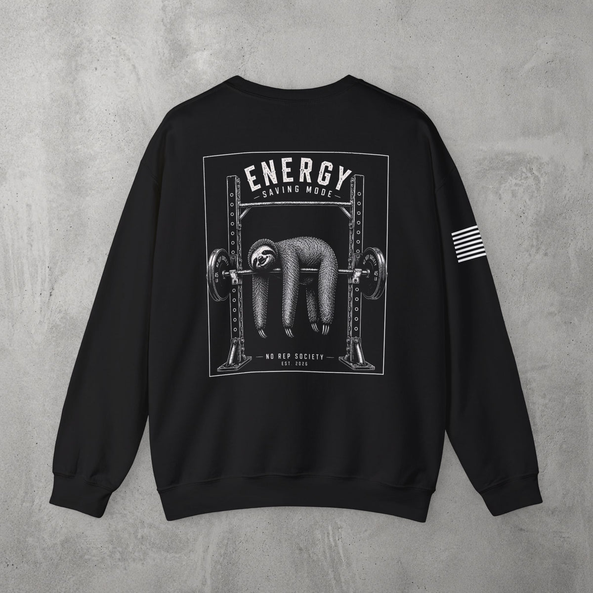 Black Energy Saving Mode Crewneck by The No Rep Society, flat lay on grey concrete, back print of a sloth hanging from a loaded barbell in a squat rack under ENERGY SAVING MODE lettering.