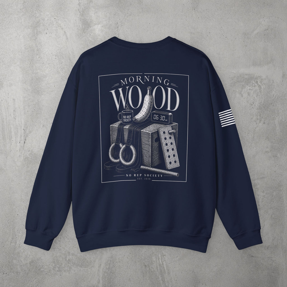 Navy Morning Wood Crewneck by The No Rep Society, flat lay on grey concrete, back print of a banana, gymnastic rings and a wooden plyo box under MORNING WOOD lettering.