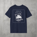 Navy Chalk Addicts Tee by The No Rep Society, flat lay on grey concrete, back print of an open bag of gym chalk spilling across a bordered frame under CHALK ADDICTS lettering.