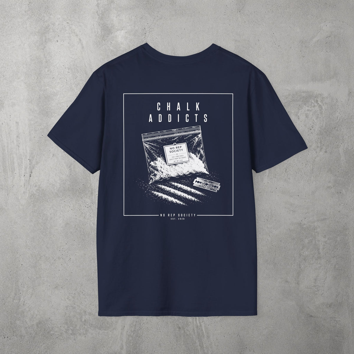 Navy Chalk Addicts Tee by The No Rep Society, flat lay on grey concrete, back print of an open bag of gym chalk spilling across a bordered frame under CHALK ADDICTS lettering.