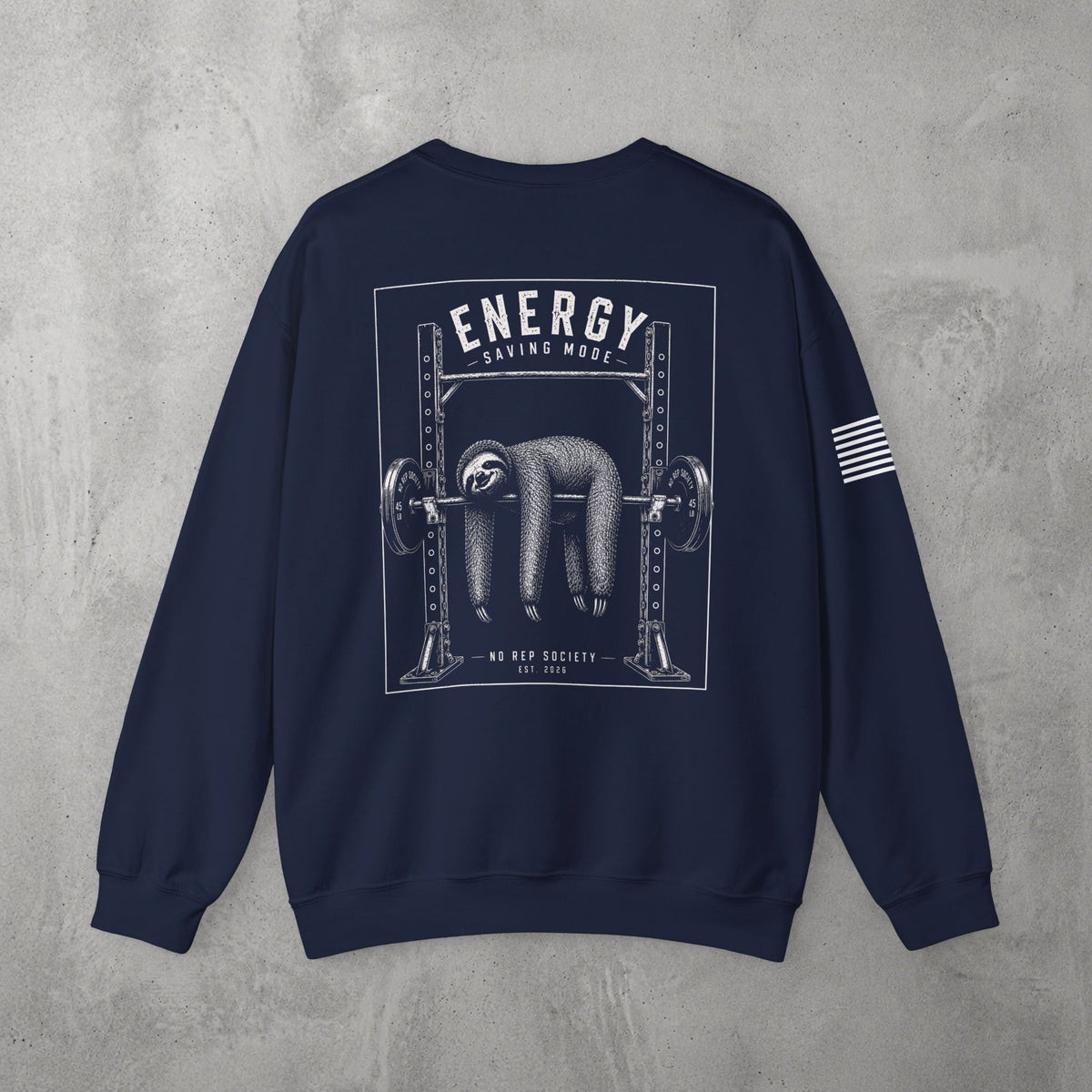 Navy Energy Saving Mode Crewneck by The No Rep Society, flat lay on grey concrete, back print of a sloth hanging from a loaded barbell in a squat rack under ENERGY SAVING MODE lettering.
