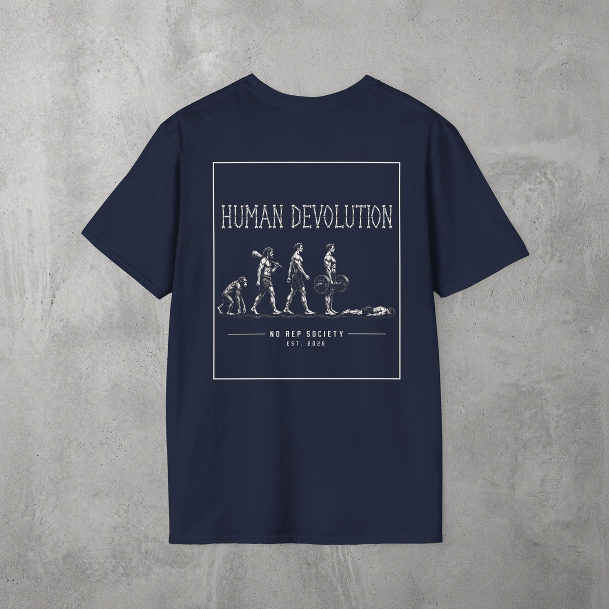 Navy Human Devolution (MEN) Tee by The No Rep Society, flat lay on grey concrete, back print of evolution-of-man silhouettes ending face-down on the floor under HUMAN DEVOLUTION lettering.