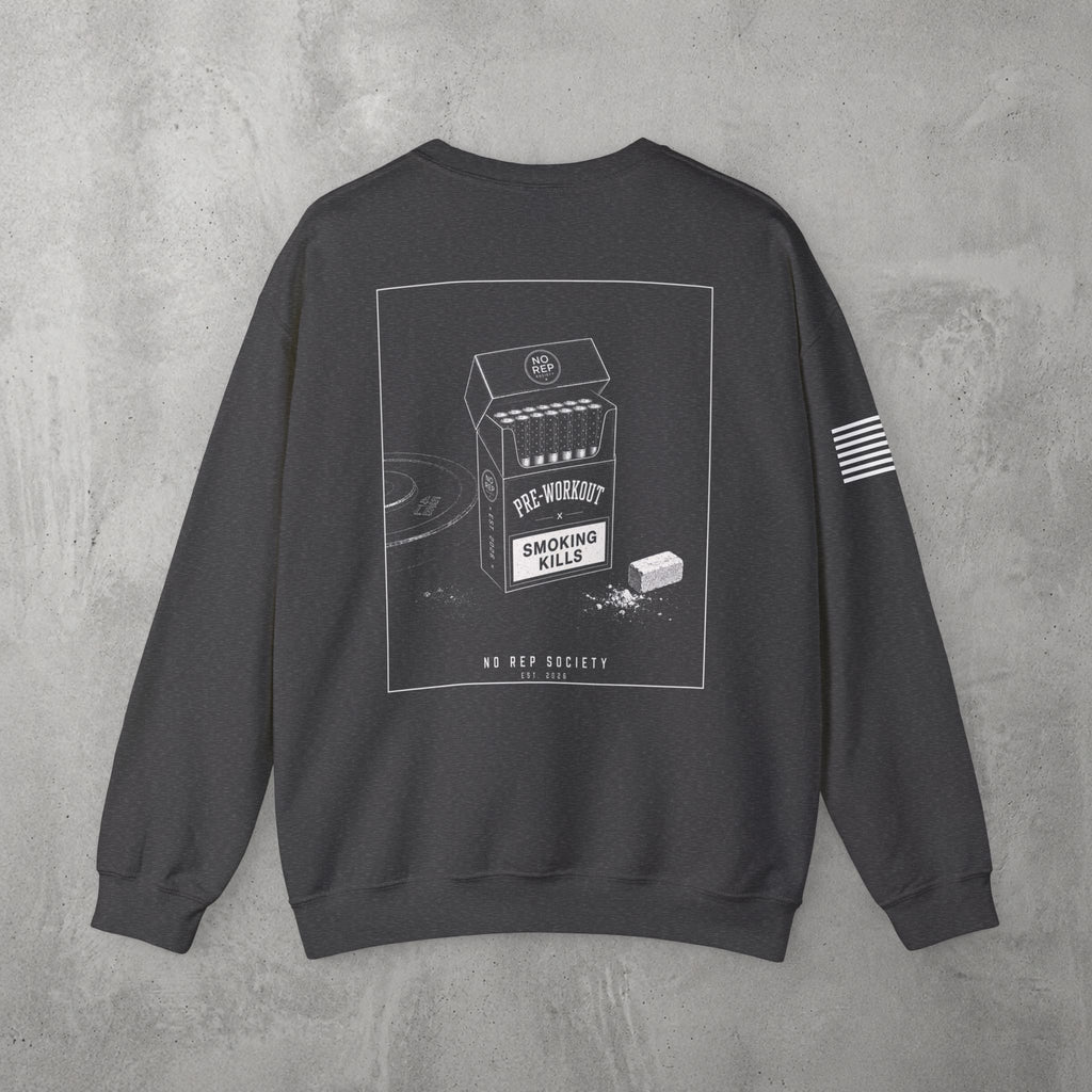 Dark Heather Pre-Workout Crewneck by The No Rep Society, flat lay on grey concrete, back print of an open cigarette pack labelled PRE-WORKOUT with a SMOKING KILLS warning and a scoop spilling powder.