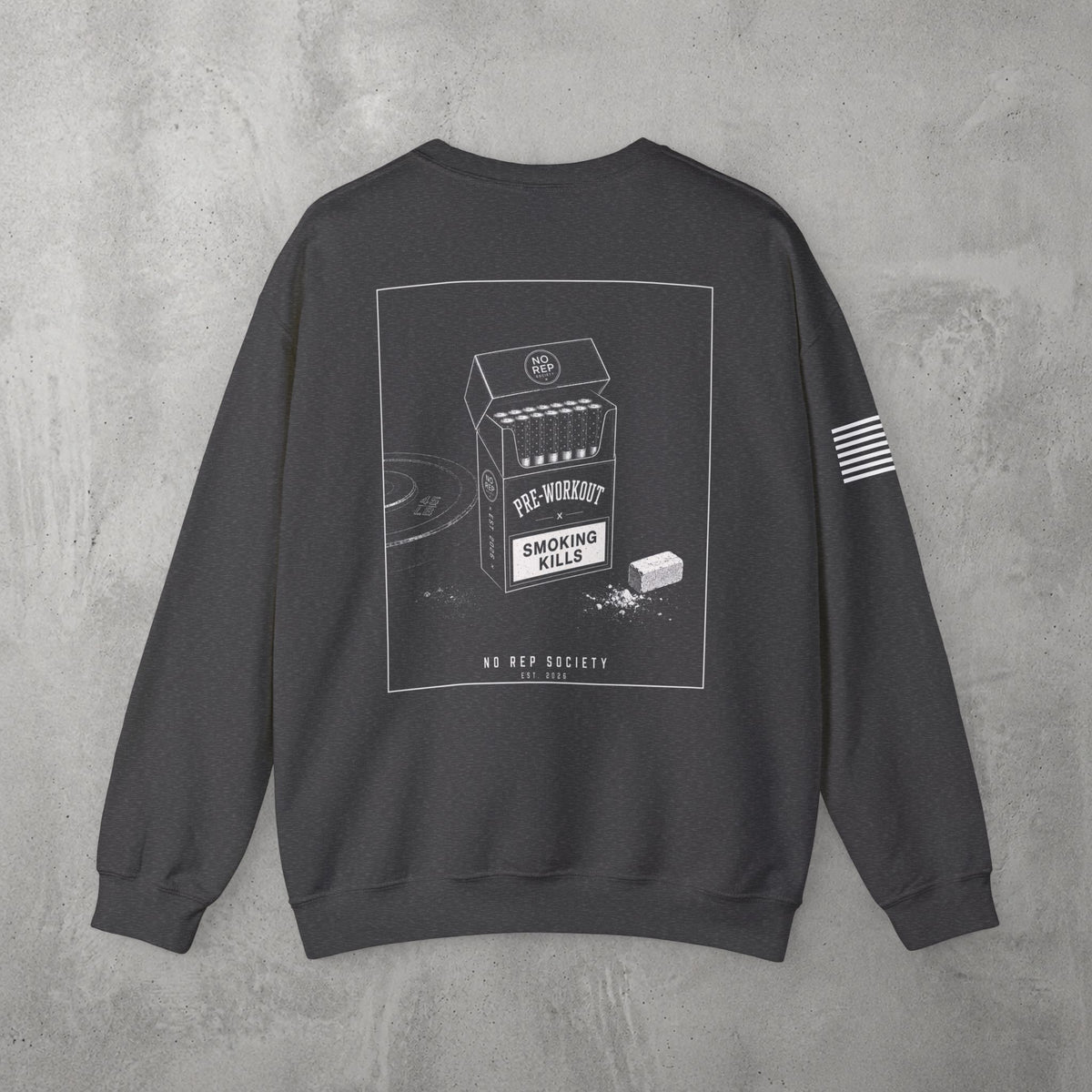 Dark Heather Pre-Workout Crewneck by The No Rep Society, flat lay on grey concrete, back print of an open cigarette pack labelled PRE-WORKOUT with a SMOKING KILLS warning and a scoop spilling powder.