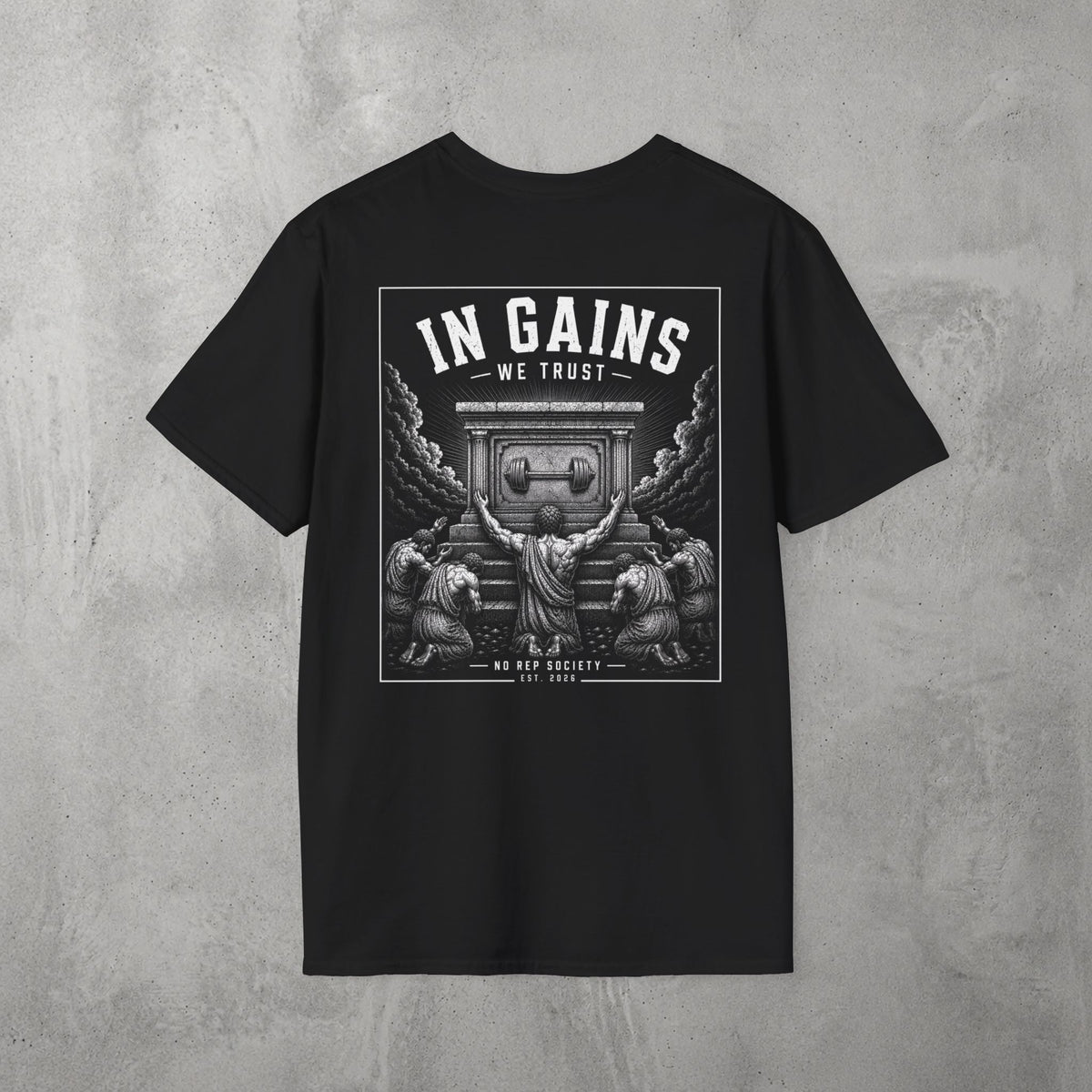 Black In Gains We Trust Tee by The No Rep Society, flat lay on grey concrete, back print of an ornate temple facade with two kneeling figures and laurel branches under IN GAINS WE TRUST lettering.