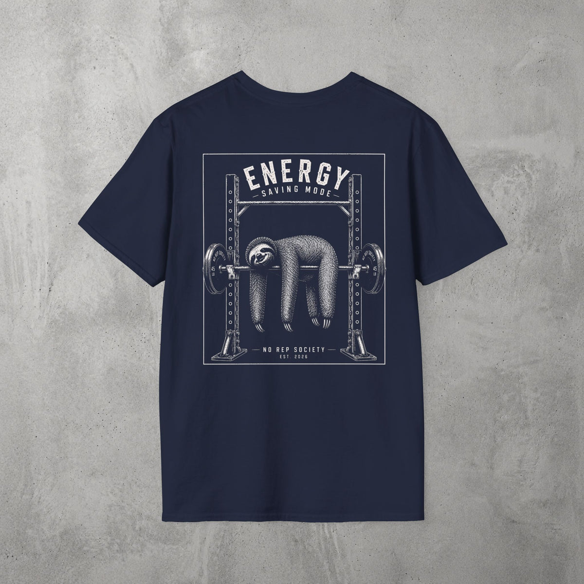 Navy Energy Saving Mode Tee by The No Rep Society, flat lay on grey concrete, back print of a sloth hanging from a loaded barbell in a squat rack under ENERGY SAVING MODE lettering.