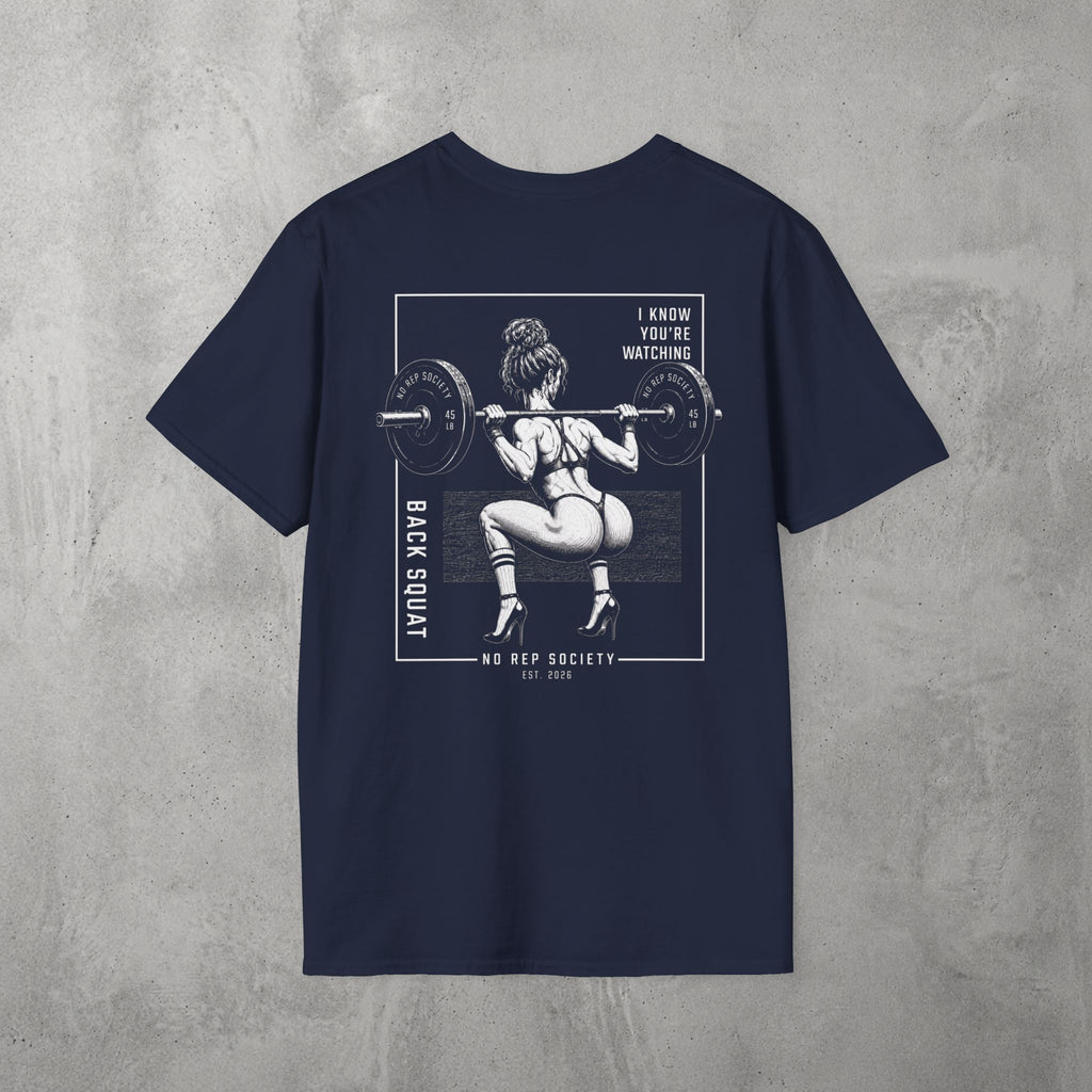 Navy I Know You're Watching Tee by The No Rep Society, flat lay on grey concrete, back print of a woman mid back-squat inside a bordered frame under I KNOW YOU'RE WATCHING lettering.