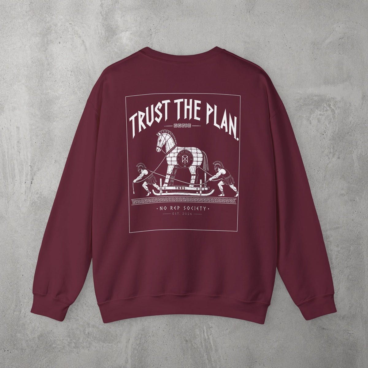 Maroon Trust The Plan Crewneck by The No Rep Society, flat lay on grey concrete, back print of the Trojan Horse with figures around it under TRUST THE PLAN lettering.