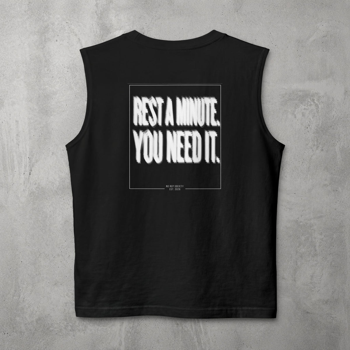 Black Rest A Minute Muscle Tank by The No Rep Society, flat lay on grey concrete, back print of REST A MINUTE. YOU NEED IT. in bold blurred capitals inside a thin frame.