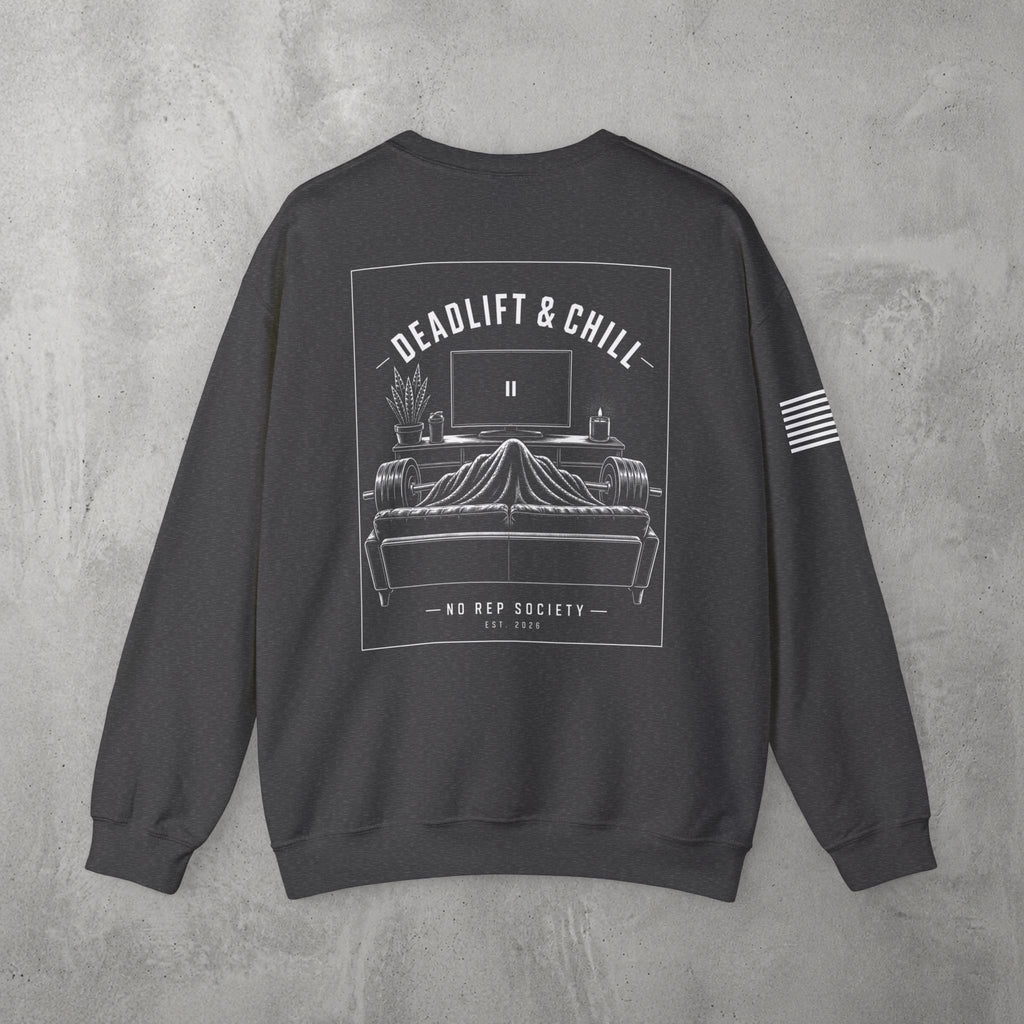 Dark Heather Deadlift & Chill Crewneck by The No Rep Society, flat lay on grey concrete, back print of a bed and television drawn in fine line art under DEADLIFT & CHILL lettering.