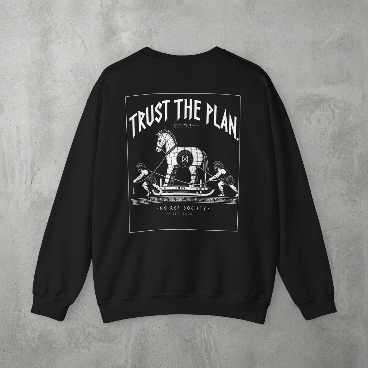 Black Trust The Plan Crewneck by The No Rep Society, flat lay on grey concrete, back print of the Trojan Horse with figures around it under TRUST THE PLAN lettering.