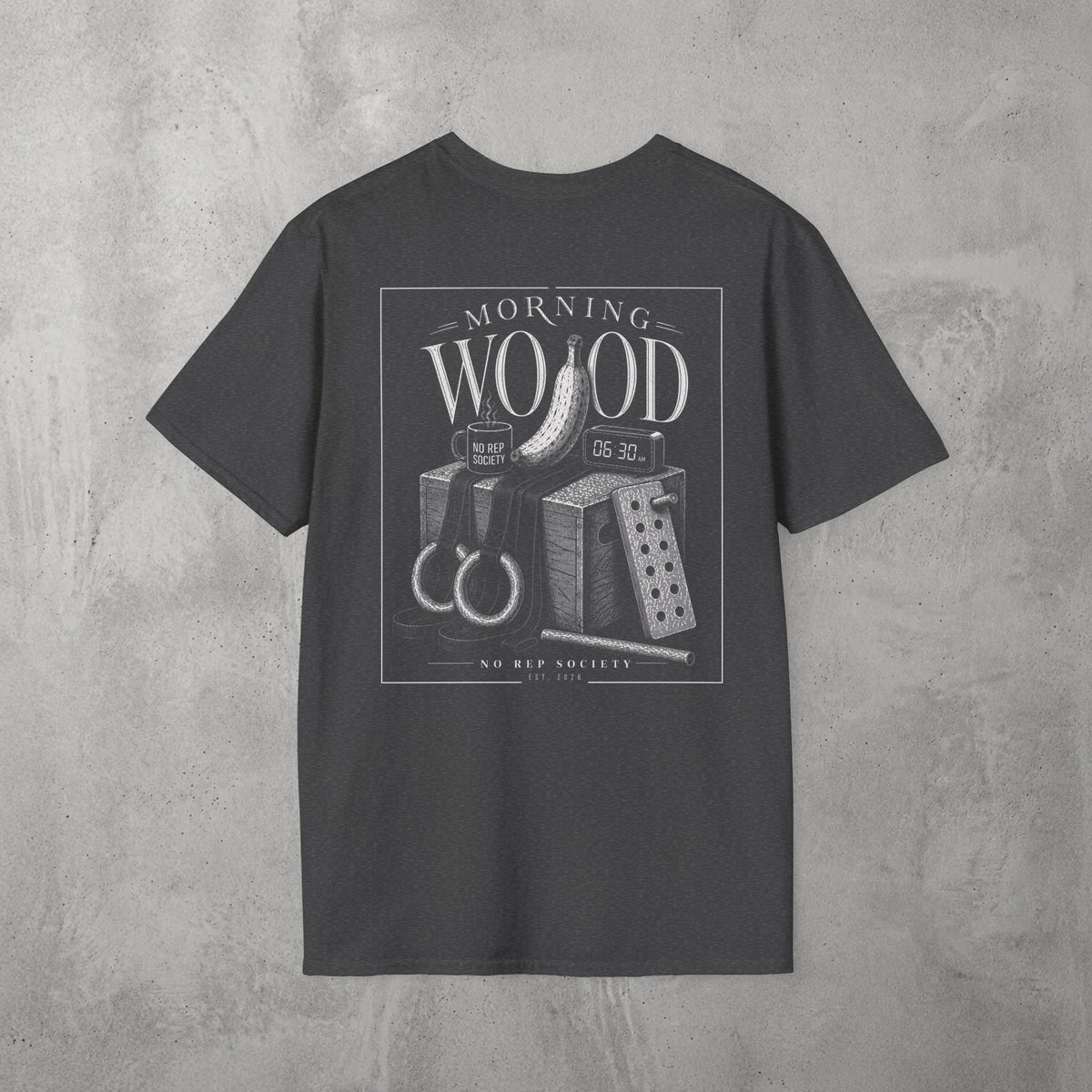 Dark Heather Morning Wood Tee by The No Rep Society, flat lay on grey concrete, back print of a banana, gymnastic rings and a wooden plyo box under MORNING WOOD lettering.