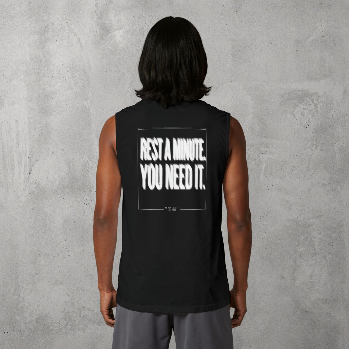 Black Rest A Minute Muscle Tank worn by a female model, back view showing the Rest A Minute print.