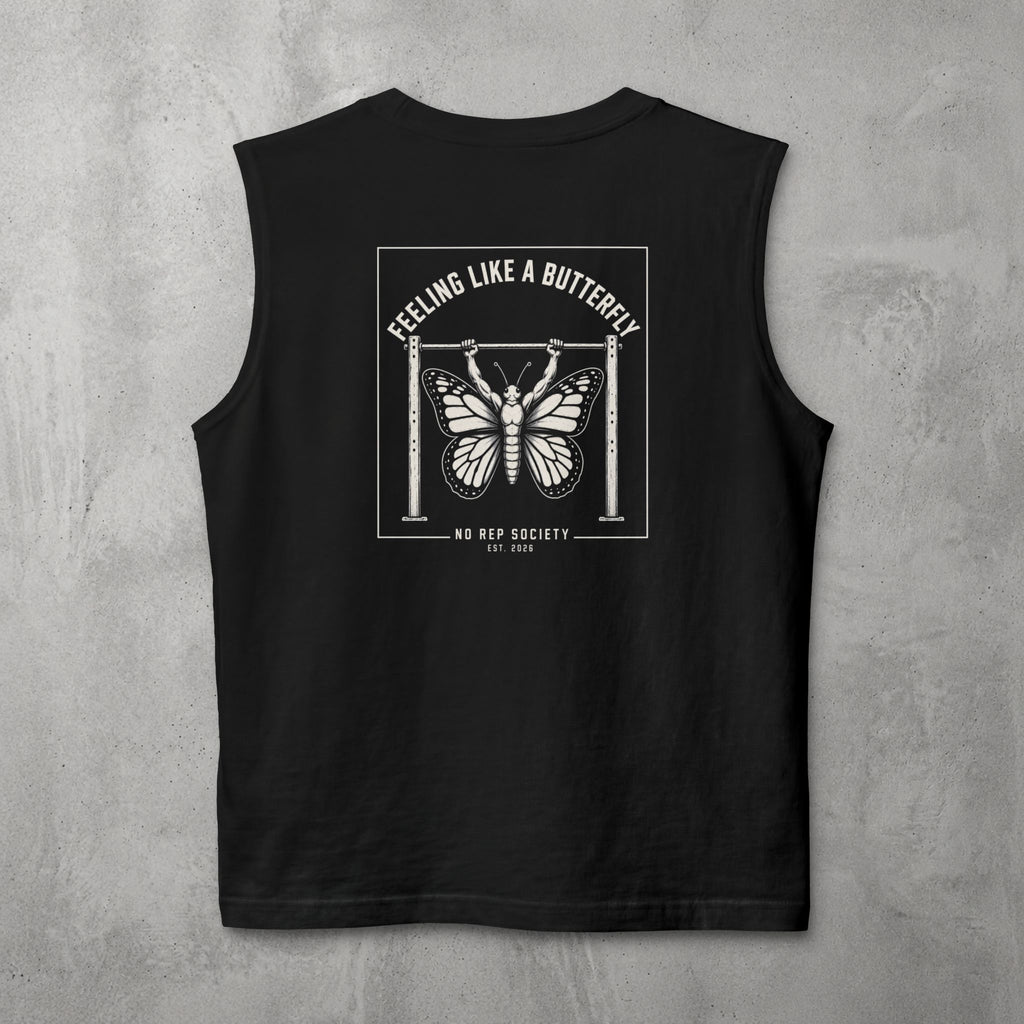 Black Feeling Like A Butterfly Muscle Tank by The No Rep Society, flat lay on grey concrete, back print of a moth with spread wings hanging between two rig uprights under FEELING LIKE A BUTTERFLY lettering.
