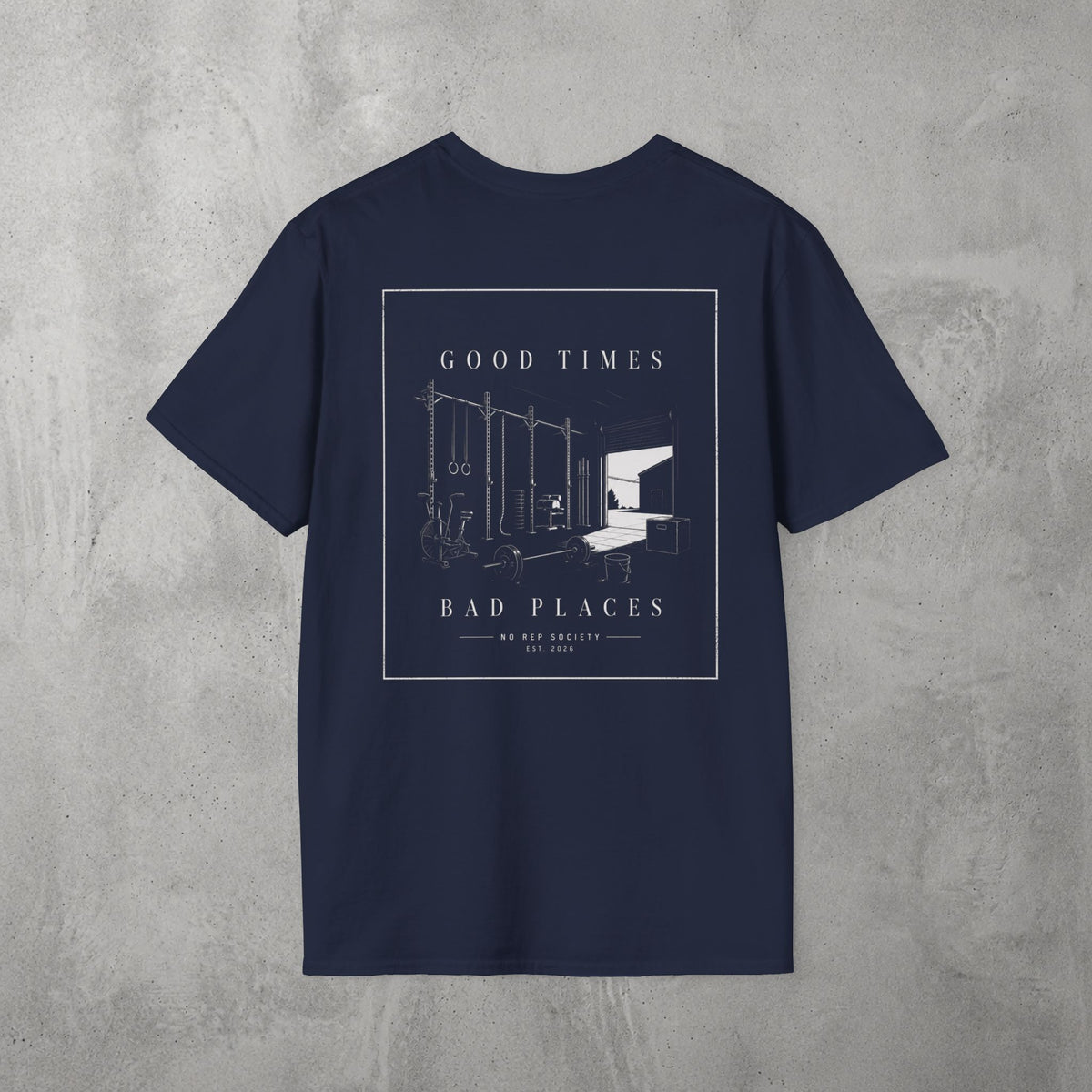 Navy Good Times, Bad Places Tee by The No Rep Society, flat lay on grey concrete, back print of a rowing machine in fine line art between GOOD TIMES and BAD PLACES lettering.