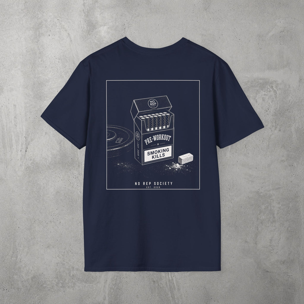 Navy Pre-Workout Tee by The No Rep Society, flat lay on grey concrete, back print of an open cigarette pack labelled PRE-WORKOUT with a SMOKING KILLS warning and a scoop spilling powder.