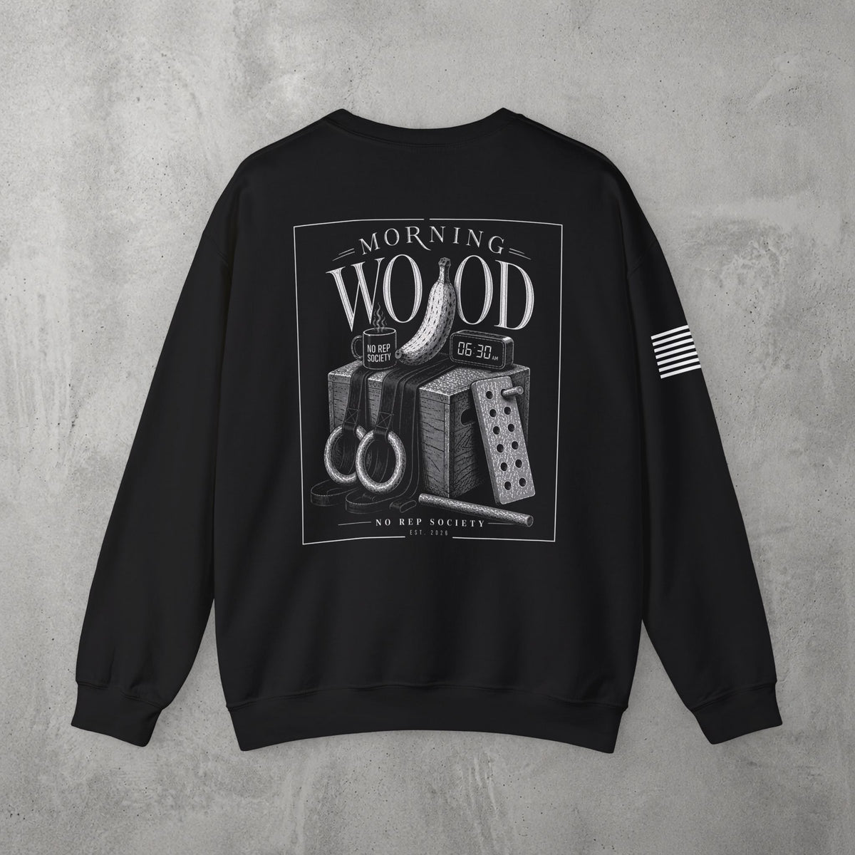 Black Morning Wood Crewneck by The No Rep Society, flat lay on grey concrete, back print of a banana, gymnastic rings and a wooden plyo box under MORNING WOOD lettering.
