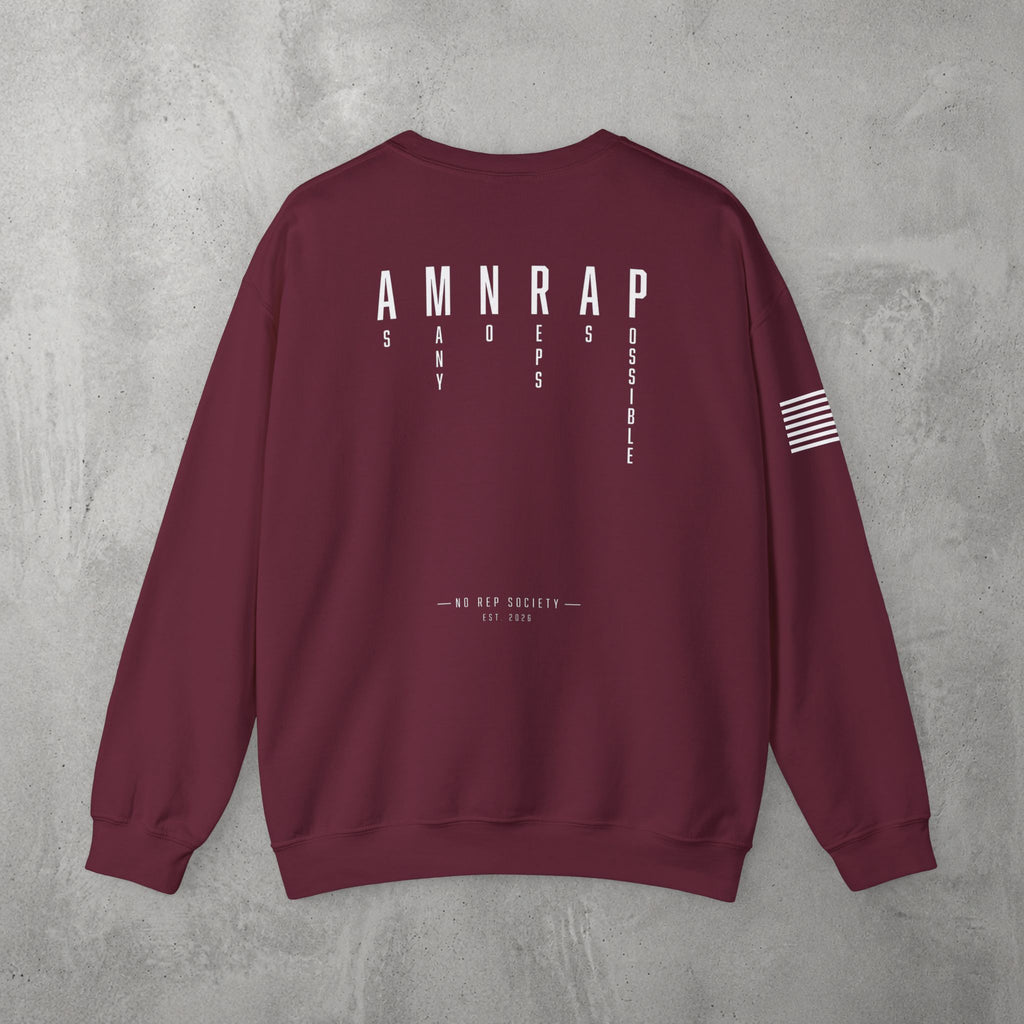Maroon AMNRAP Crewneck by The No Rep Society, flat lay on grey concrete, back print of AMNRAP in wide spaced capitals with AS MANY NO-REPS AS POSSIBLE set vertically between the letters.