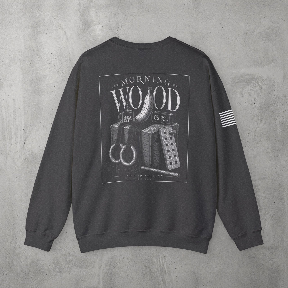 Dark Heather Morning Wood Crewneck by The No Rep Society, flat lay on grey concrete, back print of a banana, gymnastic rings and a wooden plyo box under MORNING WOOD lettering.