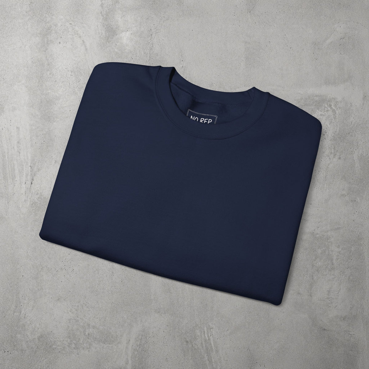 Navy Auramemnon Crewneck by The No Rep Society, folded flat on grey concrete.