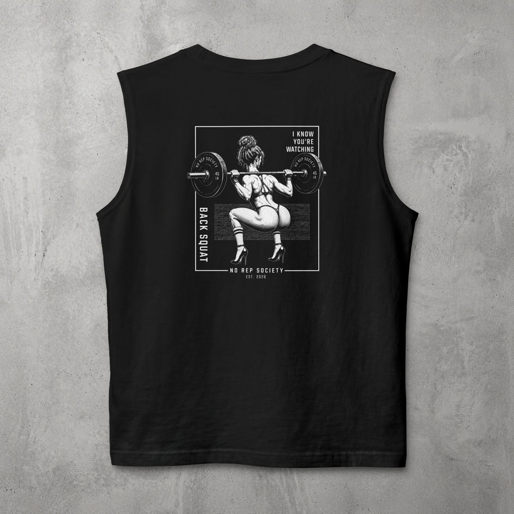 Black I Know You're Watching Muscle Tank by The No Rep Society, flat lay on grey concrete, back print of a woman mid back-squat inside a bordered frame under I KNOW YOU'RE WATCHING lettering.
