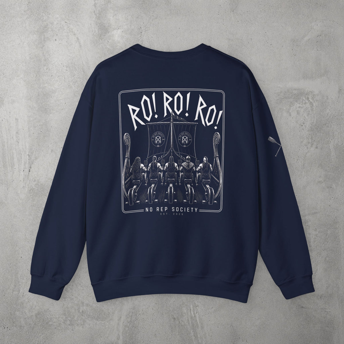 Navy RO! RO! RO! Viking Crewneck by The No Rep Society, flat lay on grey concrete, back print of a Viking longship with rows of oarsmen under sail beneath RO! RO! RO! lettering.