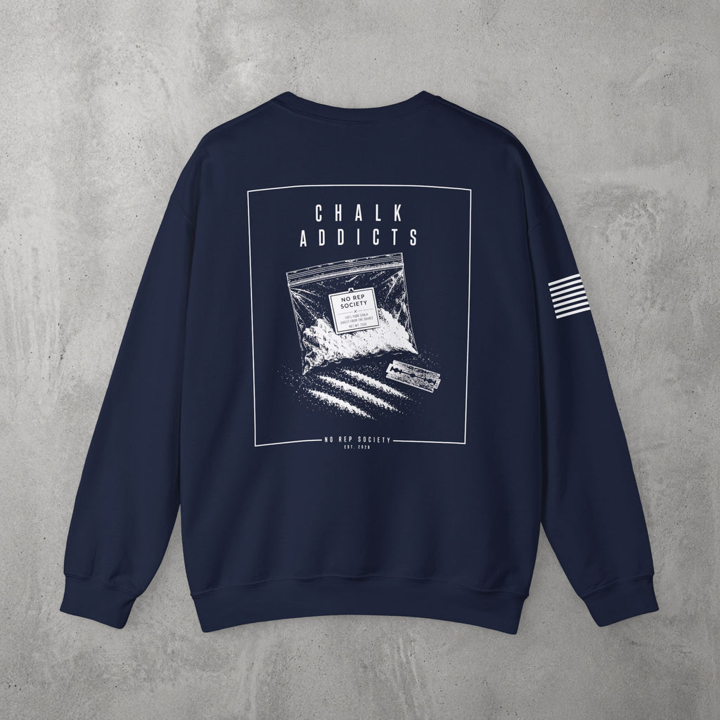 Navy Chalk Addicts Crewneck by The No Rep Society, flat lay on grey concrete, back print of an open bag of gym chalk spilling across a bordered frame under CHALK ADDICTS lettering.