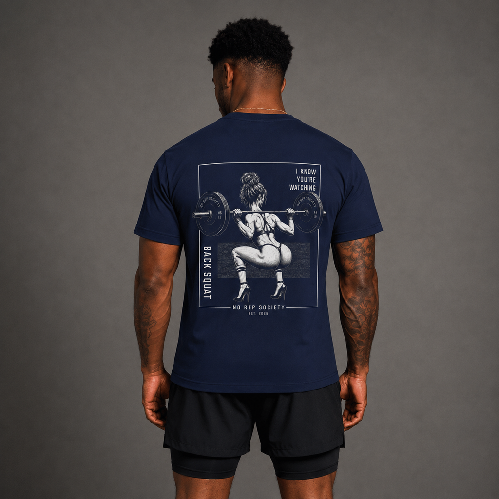 Navy I Know You're Watching Tee by The No Rep Society, worn by a male model, back view showing the I KNOW YOU'RE WATCHING print.