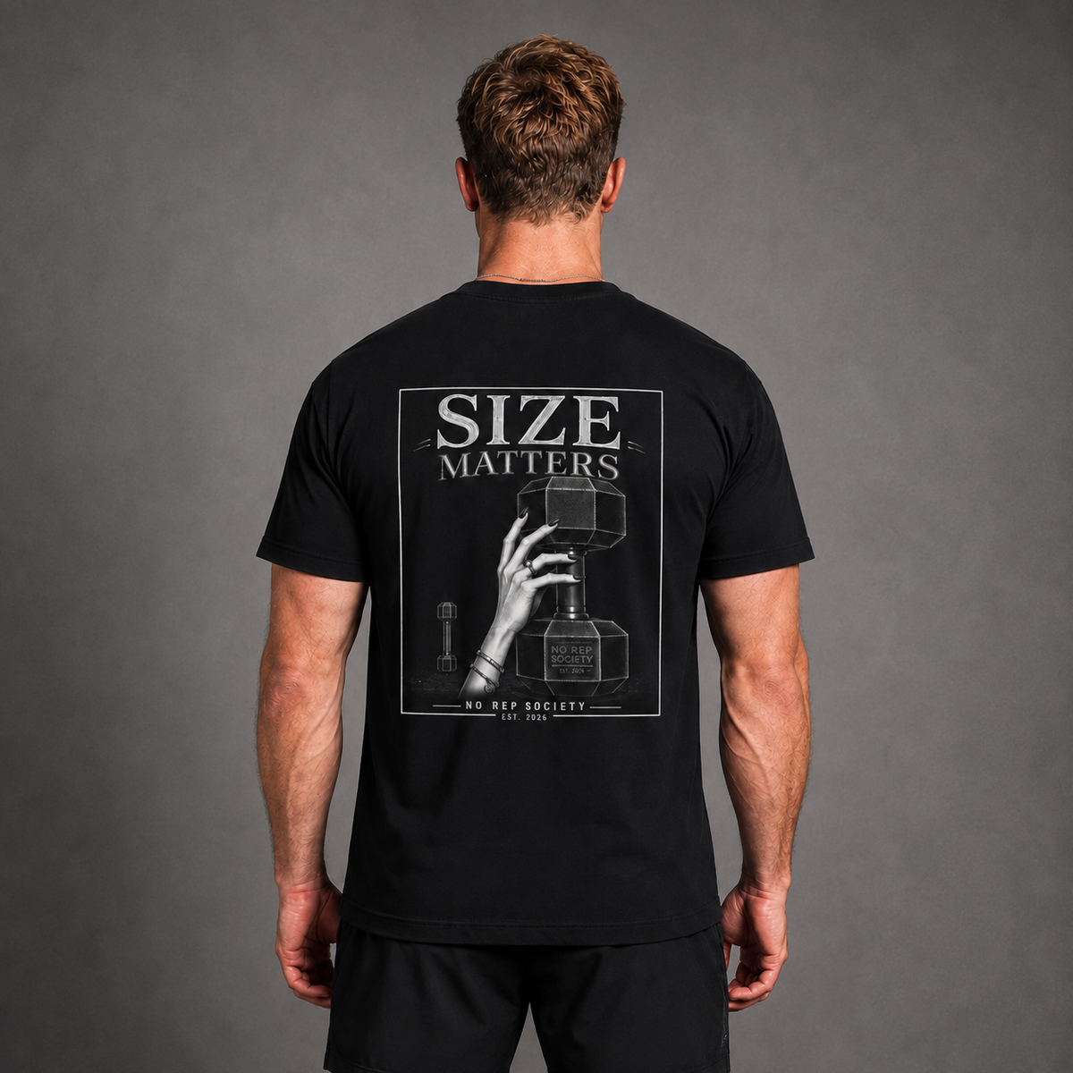 Black Size Matters Tee by The No Rep Society, worn by a male model, back view showing the SIZE MATTERS print.