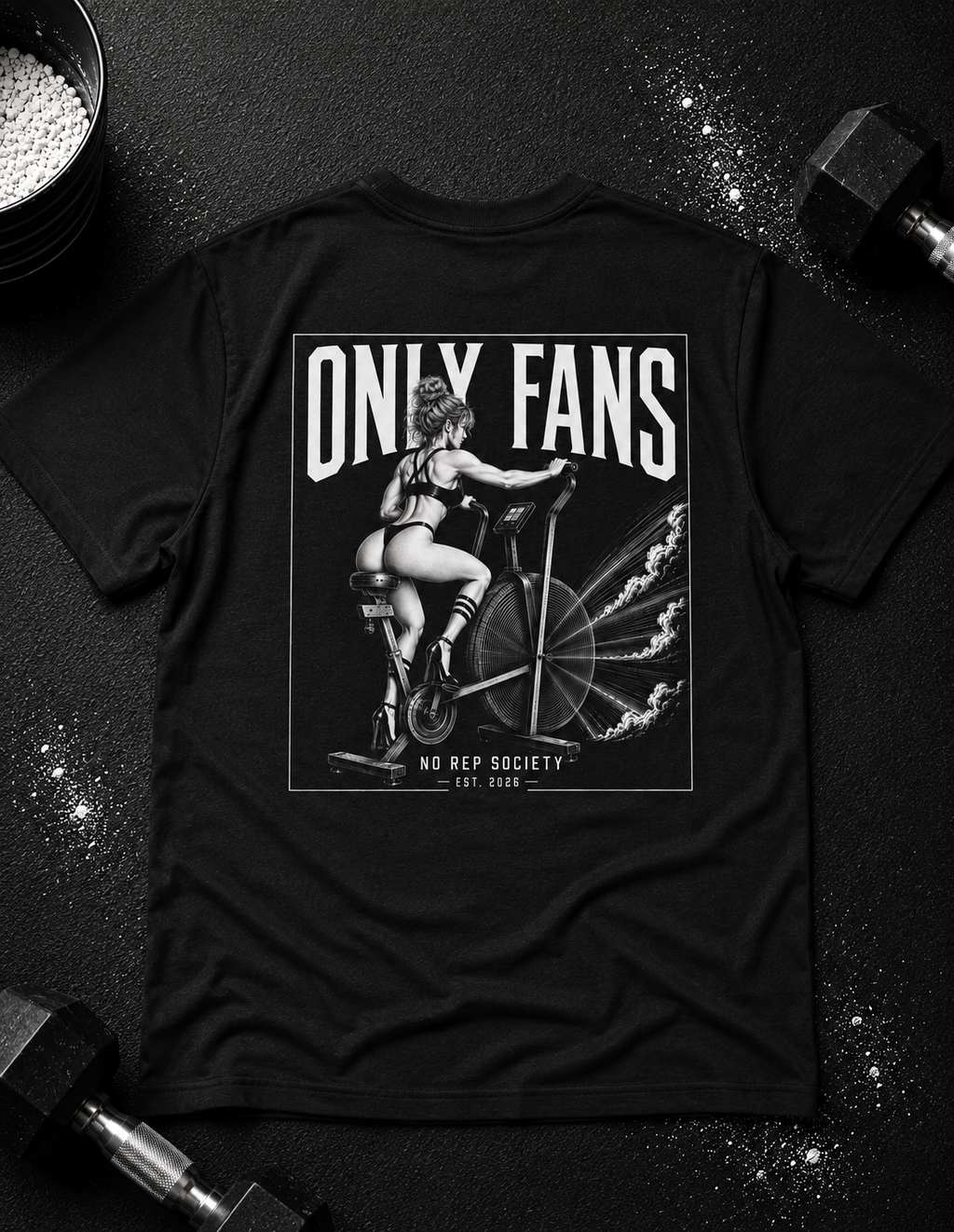 Black Only Fans Tee by The No Rep Society, laid flat on a dark gym floor between a chalk bucket and dumbbells, back print of a pin-up figure seated on a large industrial fan inside a bordered frame under ONLY FANS lettering.